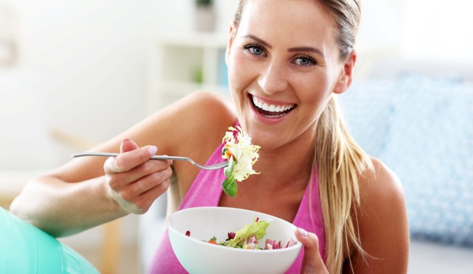 nő mosolyog salátával