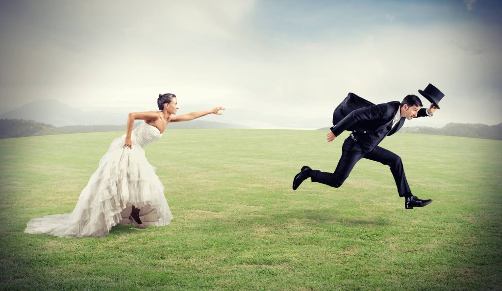 nő menyasszonyi ruhában fut a mezőn a vőlegény után