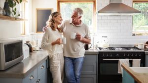 Idős pár kávézgat otthon a konyhában