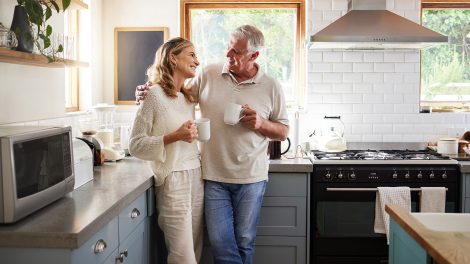 Idős pár kávézgat otthon a konyhában