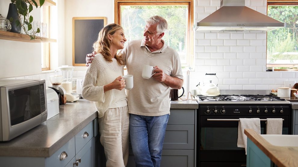 Idős pár kávézgat otthon a konyhában