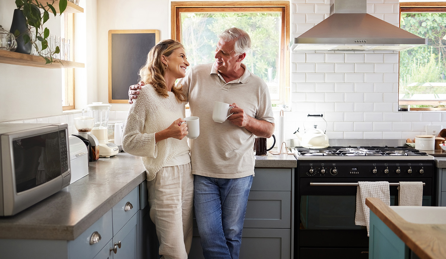 Idős pár kávézgat otthon a konyhában