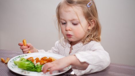 halrudacskát és sült krumplit eszik egy cuki kislány