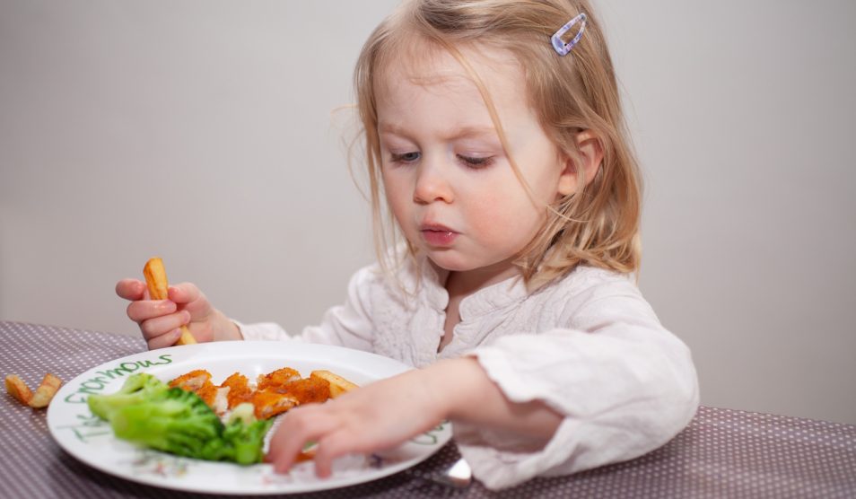 halrudacskát és sült krumplit eszik egy cuki kislány