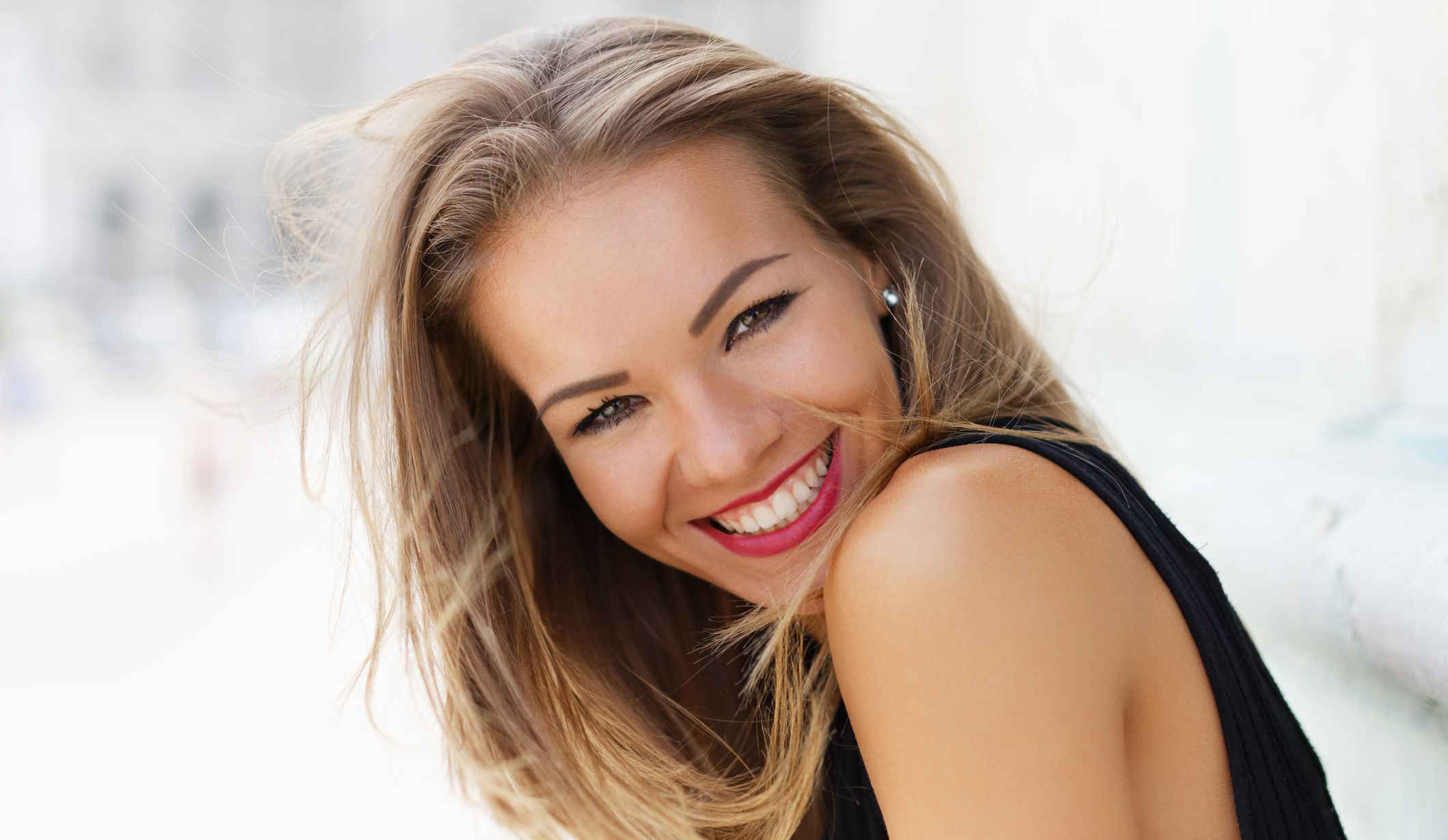 csinos fiatal nő mosolyog a kamerába