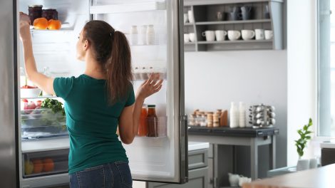 hűtő belső hőmérsékletét állítja be a termosztáton egy nő