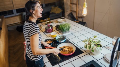 indukciós főzőlapon főz boldogan egy nő