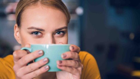 nő maga elé teszi a bögréjét