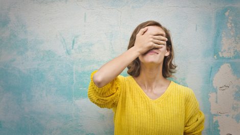 nő az arcát a kezével eltakarja