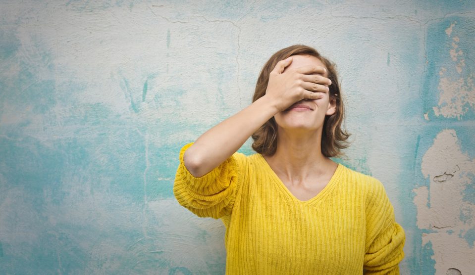 nő az arcát a kezével eltakarja
