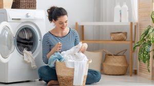 nő fehér mosás készít be a mosógépbe