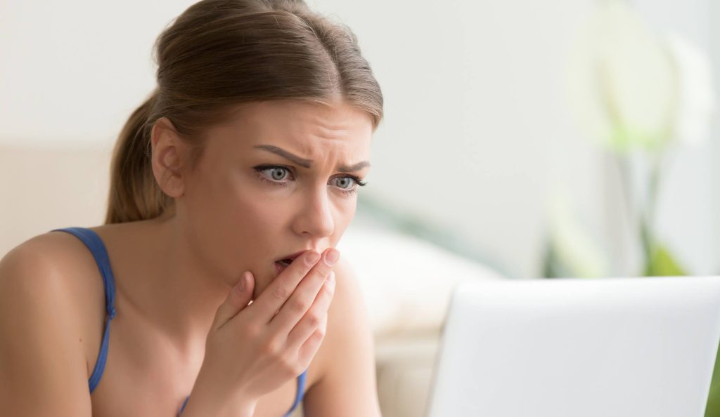 Nő aggódva olvas valamit a laptopján