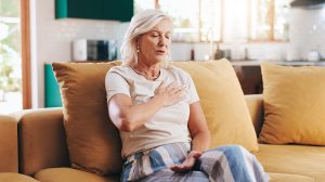 Idős nő otthon a kanapén szívrohamot kap