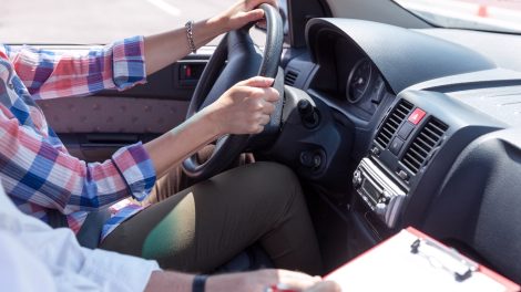 Egy férfi vezet, mellette ül az oktató