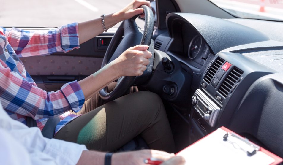 Egy férfi vezet, mellette ül az oktató