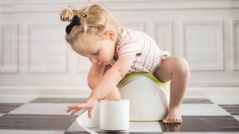 kislány a bilin wc-papírral játszik