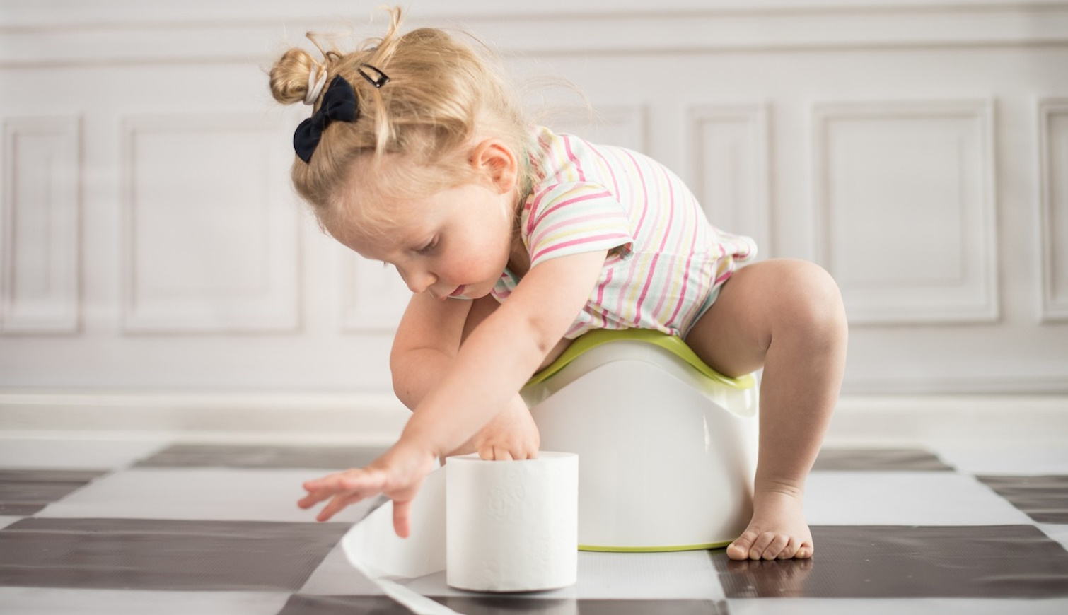 kislány a bilin wc-papírral játszik