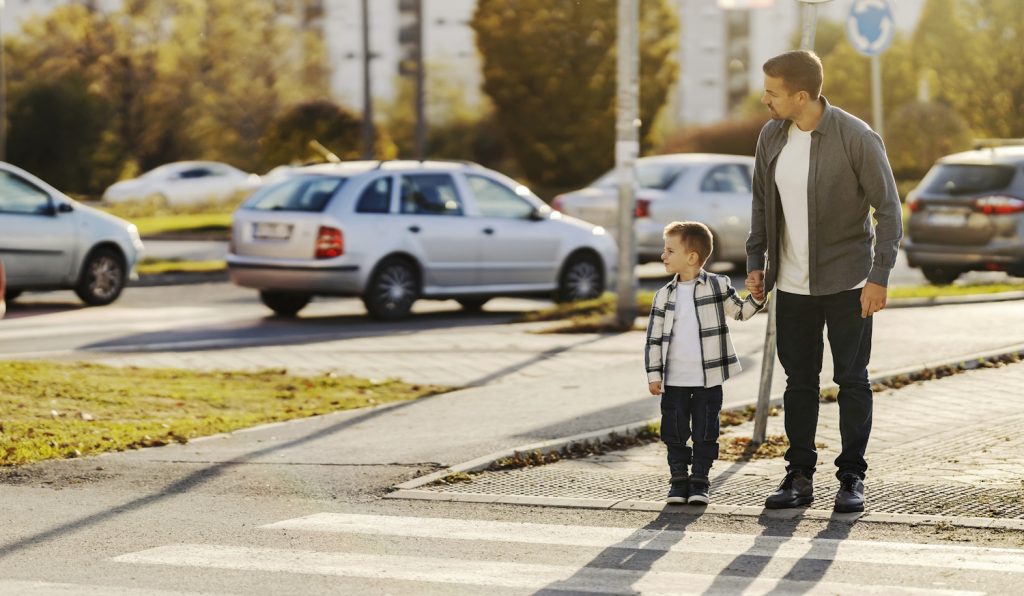 apa és fia állnak a zebránál figyelik a forgalmat
