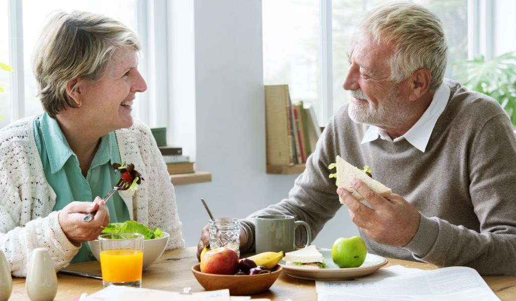 idős pár egészséges ételeket eszik, nevetve