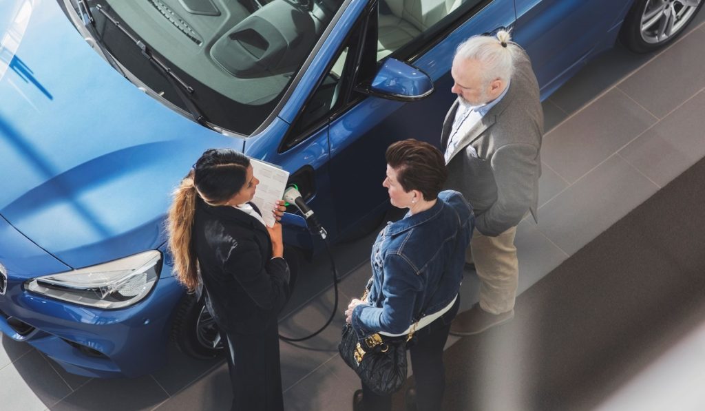 használt autót vesz egy idős házaspár a kereskedésben