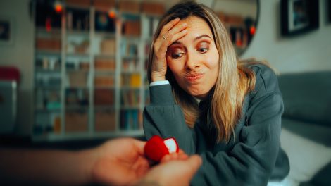 Fintoró nő, akinek eljegyzési gyűrűt mutatnak