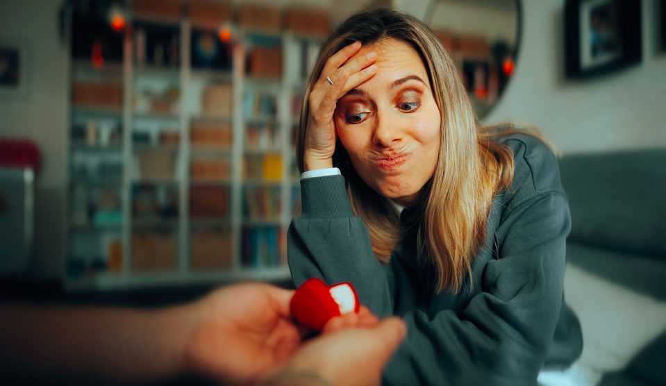 Fintoró nő, akinek eljegyzési gyűrűt mutatnak