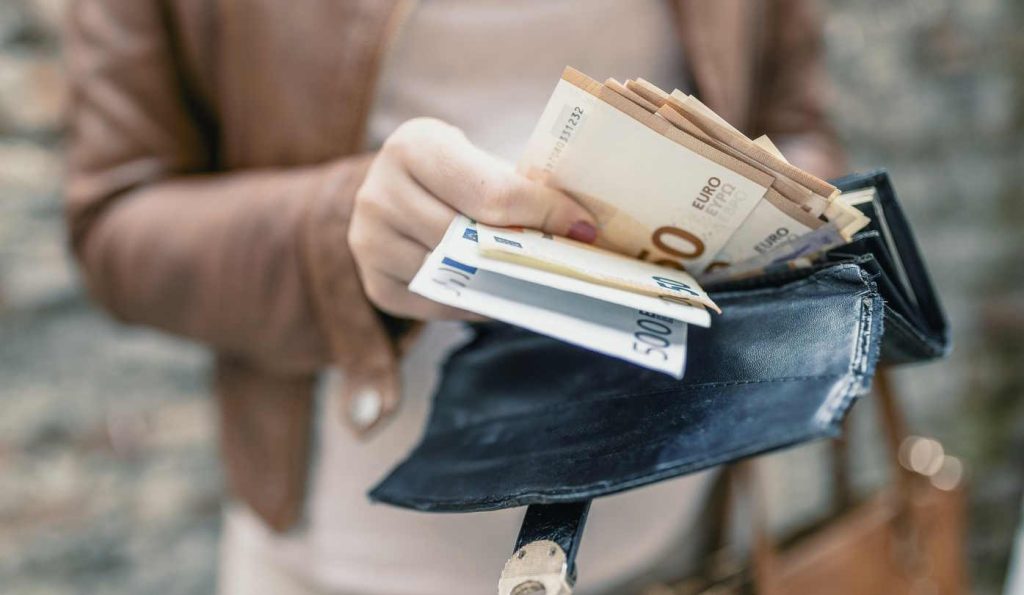 Nő pénzt tart a kezében