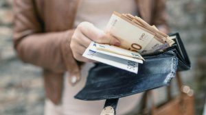 Nő pénzt tart a kezében