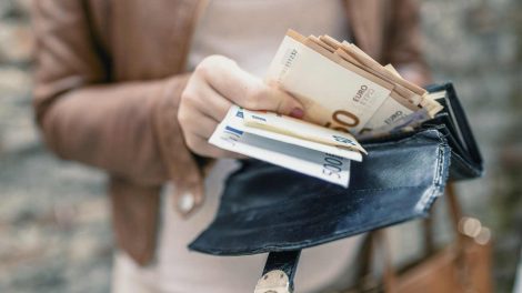 Nő pénzt tart a kezében