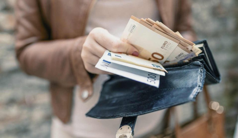 Nő pénzt tart a kezében