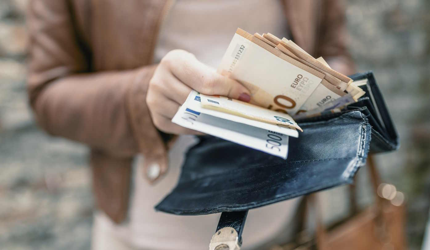 Nő pénzt tart a kezében
