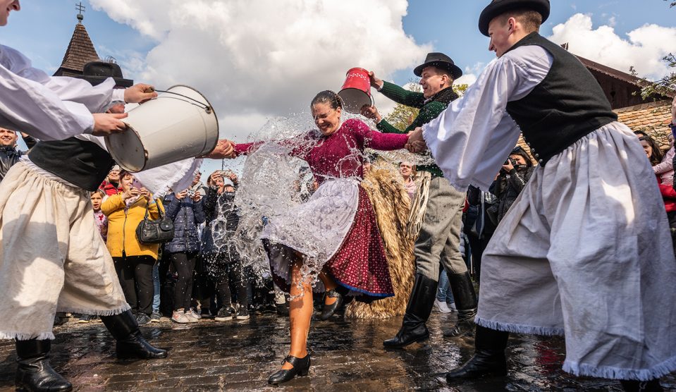 Hollókő, a fiúk a hagyományoknak megfelelően vizet hintenek a lányokra Húsvétkor.