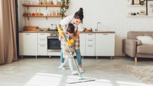 gy kislány és az édesanyja együtt takarítanak a házban, a gyerek felmossa a konyha padlóját. Egy aranyos kis segítő lány felmosóronggyal tisztítja a padlót, egy boldog család pedig együtt rendbe teszi a szobát