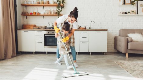 gy kislány és az édesanyja együtt takarítanak a házban, a gyerek felmossa a konyha padlóját. Egy aranyos kis segítő lány felmosóronggyal tisztítja a padlót, egy boldog család pedig együtt rendbe teszi a szobát