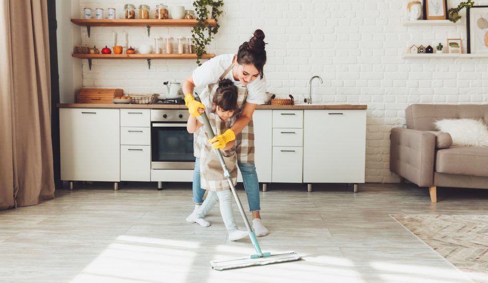 gy kislány és az édesanyja együtt takarítanak a házban, a gyerek felmossa a konyha padlóját. Egy aranyos kis segítő lány felmosóronggyal tisztítja a padlót, egy boldog család pedig együtt rendbe teszi a szobát
