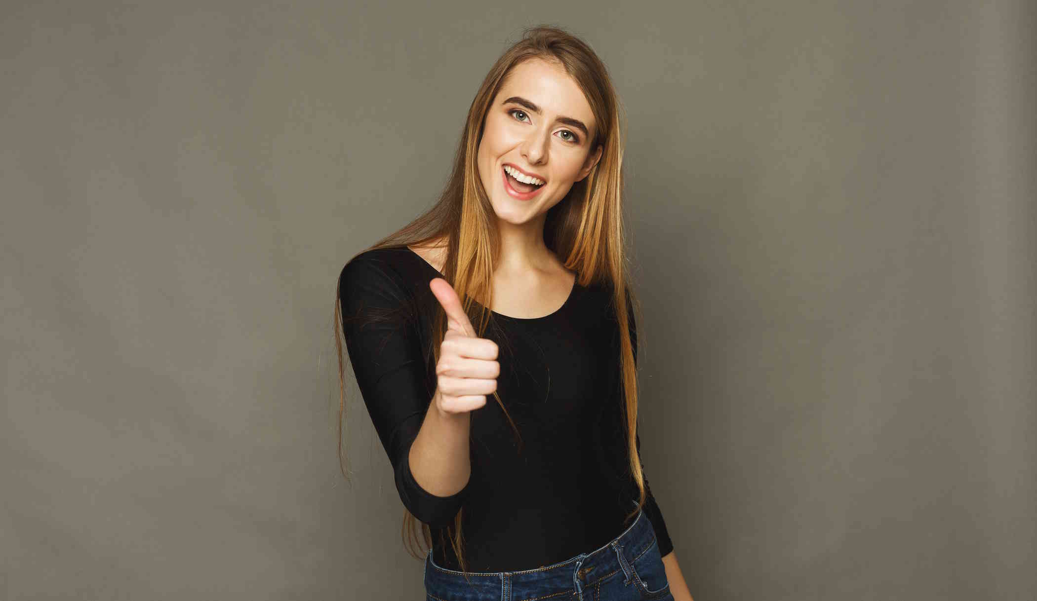 Nő barna háttért előtt mutatja, hogy minden oké