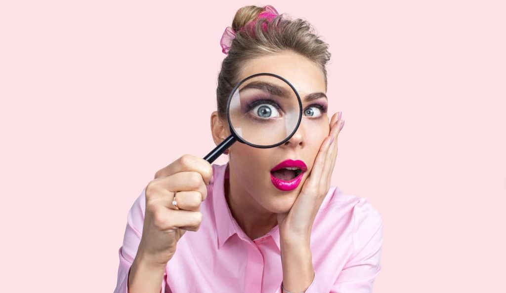 nő belenéz a nagyítóba