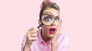 nő belenéz a nagyítóba