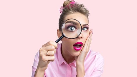 nő belenéz a nagyítóba