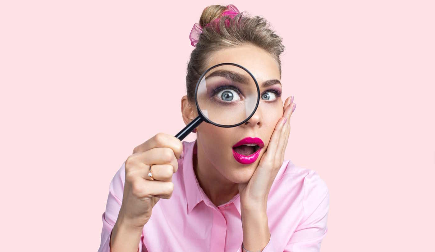 nő belenéz a nagyítóba