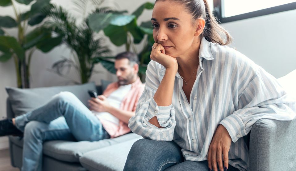 Dühös, morgues pár ül a kanapén