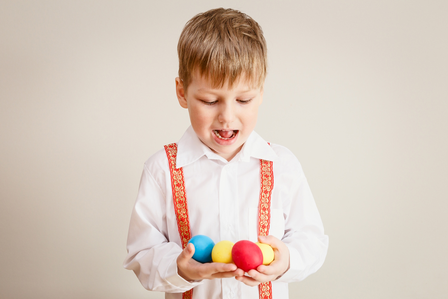 Kisfiú fogja akezében a húsvéti tojásokat