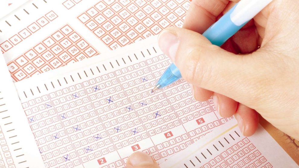 Nő lottószelvényt tölt ki