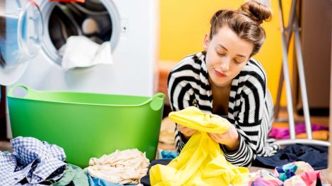 Nő nézi a mosás után a foltot a ruhán