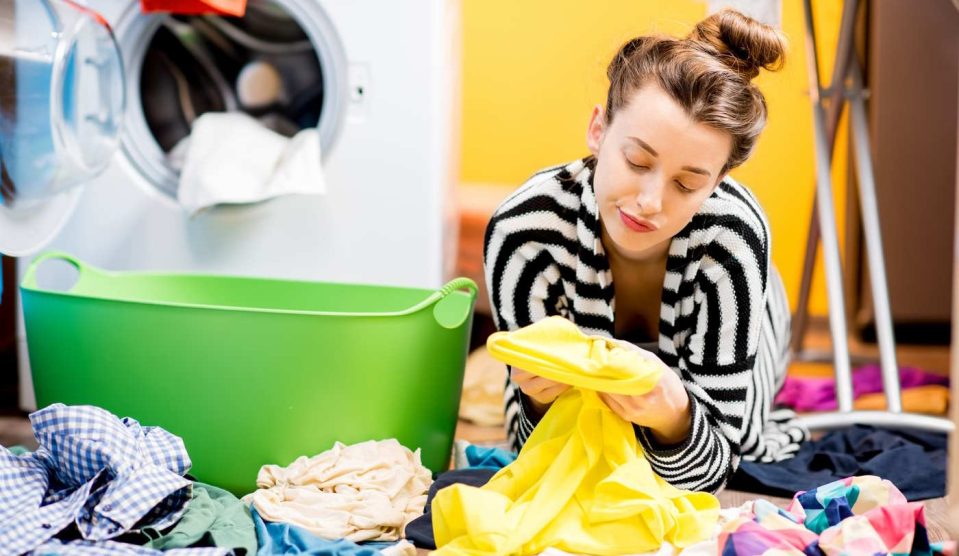 Nő nézi a mosás után a foltot a ruhán