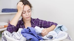 nő mosás után nézi a ruhákat