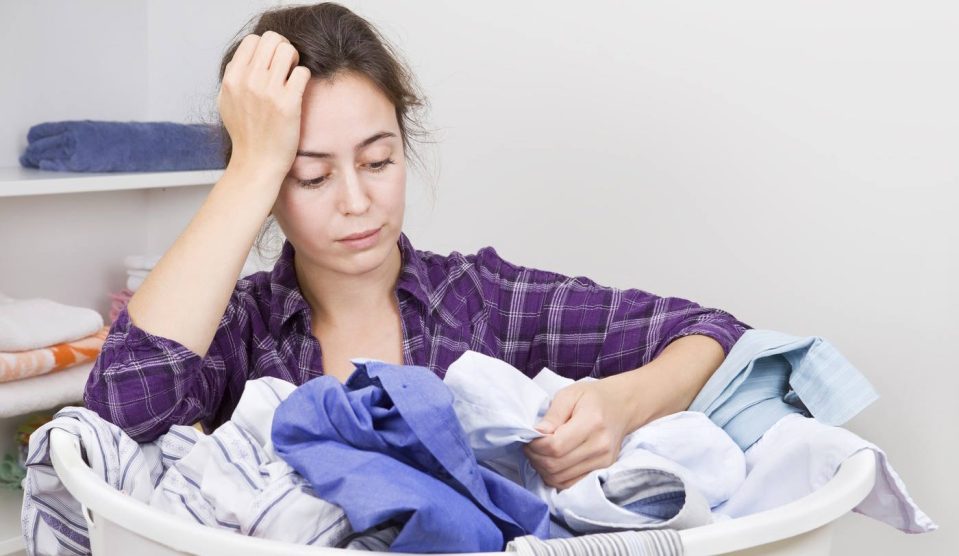 nő mosás után nézi a ruhákat