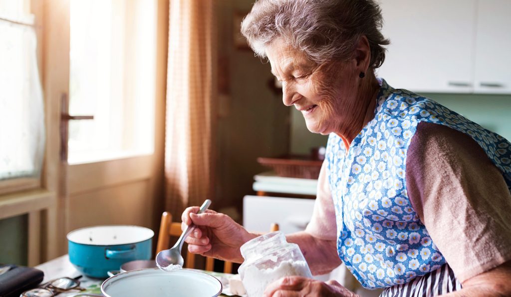 öreg nagymama húsvéti foszlós kalácsot süt a konyhában
