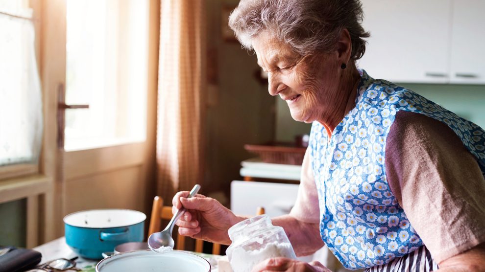 öreg nagymama húsvéti foszlós kalácsot süt a konyhában