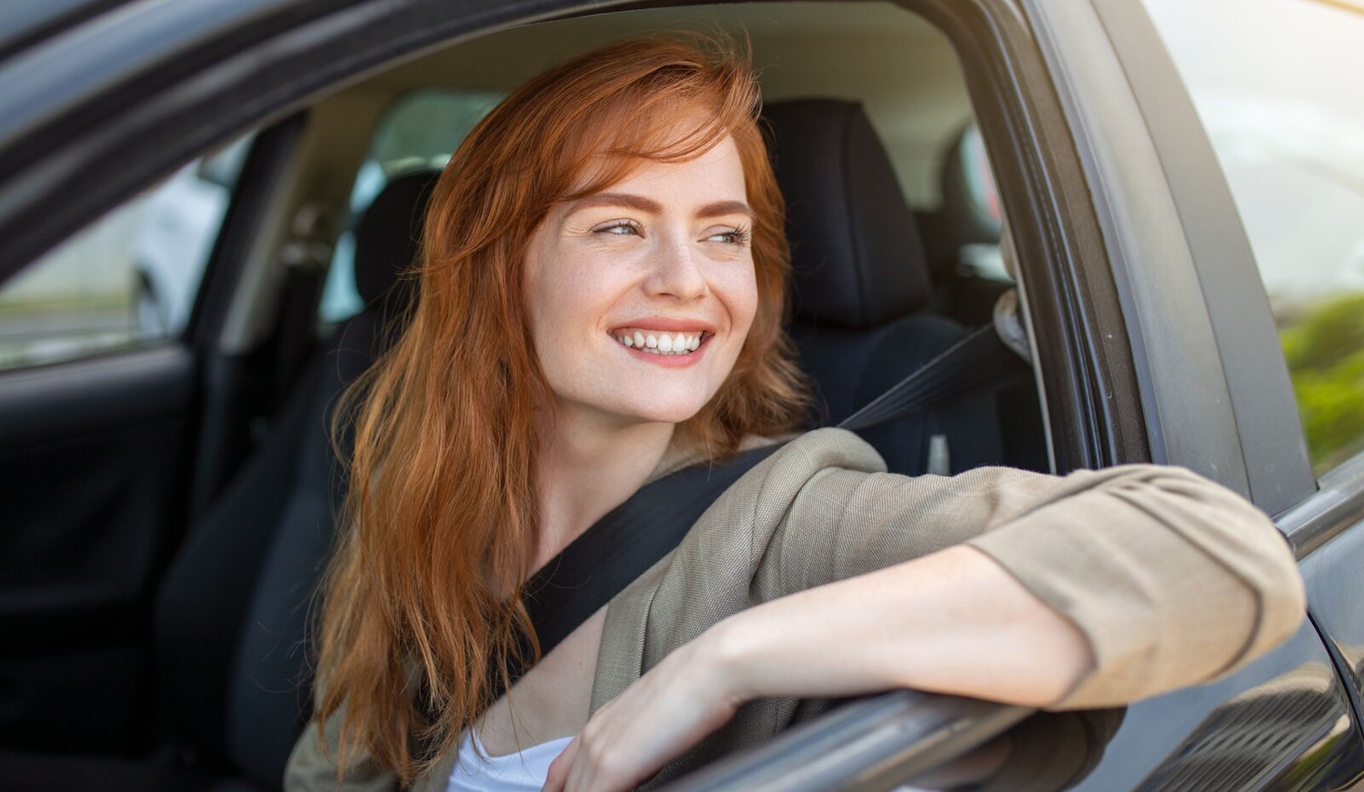 vörös nő a volánnál autóban